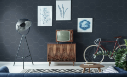 Salon, niebieska kanapa, pod ścianą półka w stylu retro na niej telewizor, na ścianie obrazy, ściana wyłożona Hexa Element Navy 23x27 płytka bazowa heksagonalna