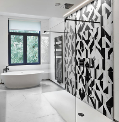 Łazienka, pod oknem biała wanna wolnostojąca, przy ścianie prysznic, podłoga wyłożona białymi płytkami, ściana przy prysznicu wyłożona Vernazza Regio 20x50 płytka ścienna imitująca marmur