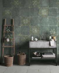 Łazienka, przy ścianie na półce szara umywalka, niżej półka z ręcznikami, obok dekoracyjny wieszak z drabiny, na podłodze dwa wiklinowe kosze, ściana wyłożona gładkimi płytkami zielonymi z kolekcji Kintsugi oraz Kintsugi Green Basi Natural 30,5x30,5 płytk