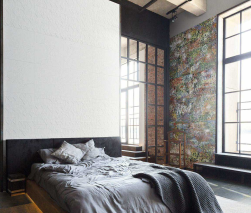 Sypialnia, na łóżku pościel i narzuta w szarym kolorze, duże okno, ściana przy oknie wyłożona kolorowymi płytkami, nad łóżkiem na ścianie wyłożone Cracked White Origami Matte Rect. 44,63x119,3 płytka ścienna imitująca beton