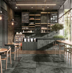 Wnętrze kawiarni, stoliki i krzesła, na podłodze i ścianie Mud Anthracite Natural 59,2X59,2 płytka imitująca beton