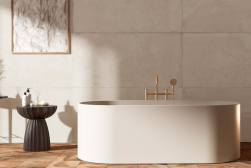 Wanna wolnostojąca w białym kolorze, obok stolik z akcesoriami do kąpieli, na podłodze płytki w brązowym kolorze, ściana wyłożona Terracota Cream Natural 59,2x59,2 płytka imitująca beton