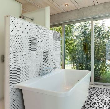 Biała łazienka z wanną wolnostojącą, schowanym za ścianą prysznicem oraz dużymi oknami