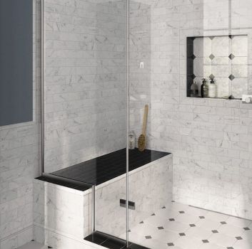 Biało-szara łazienka z dużym prysznicem z ławeczką w środku, wnęką na kosmetyki i brązową półką na ręczniki