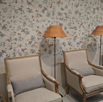 Beżowy salon z beżowymi fotelami oraz bambusowymi lampkami