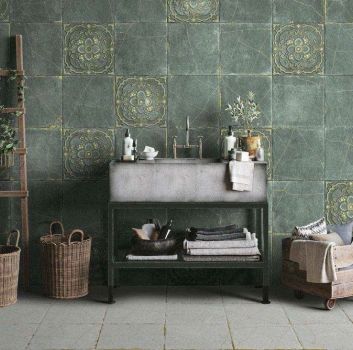 Łazienka ze ścianą wyłożoną zielonymi płytkami dekoracyjnymi Kintsugi z betonową umywalką, kosmetykami, drabiną, koszami wiklinowymi i skrzynką