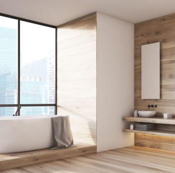 Przestronna łazienka z drewnianymi elementami i dużą wanną wolnostojącą