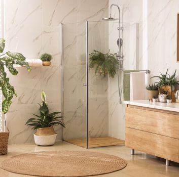 Przytulna łazienka z kabiną prysznicową, drewnianą szafką z umywalką nablatową, lustrem i kwiatami w donicach