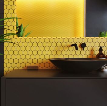 Łazienka z żółtą mozaiką za umywalką, czarną ścianą i szafką z czarną umywalką nablatową i baterią podtynkową oraz dużym lustrem