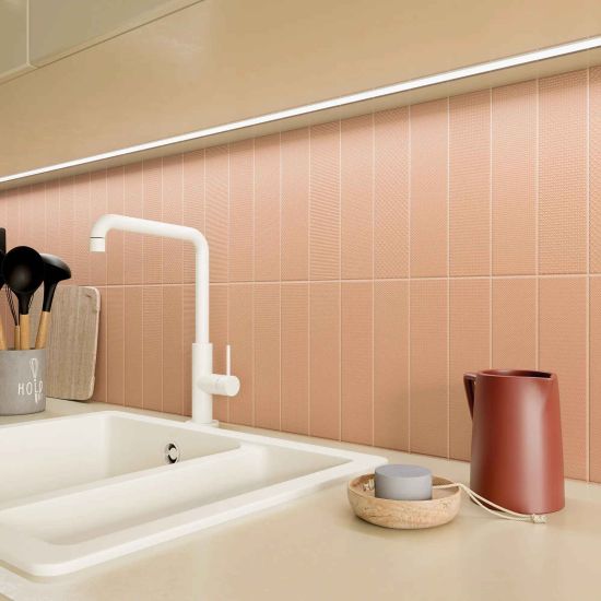 Ściana w kuchni między meblami wyłożona pomarańczowymi cegiełkami dekoracyjnymi Texiture Pattern Mix Cotto Matt, z jasnym blatem ze zlewem i naczyniami