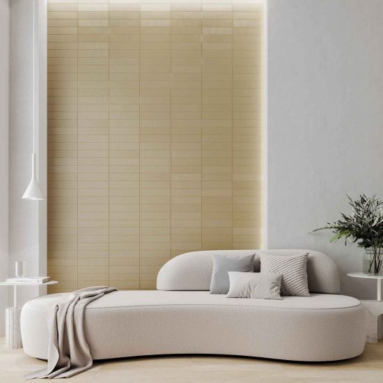 Salon z fragmentem ściany wyłożonym złotymi cegiełkami dekoracyjnymi Texiture Pattern Mix Brass Gloss, z jasną kanapą, białymi stoliczkami i lampą wiszącą