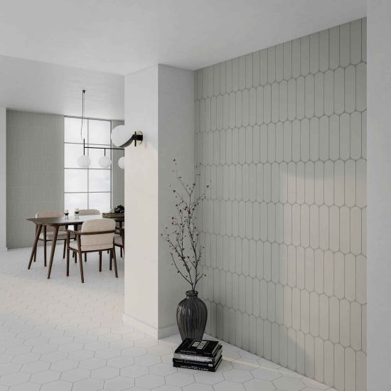 Korytarz otwarty na jadalnię ze ścianą wyłożoną szarymi cegiełkami Grace O Grey Matt z dzbanem z gałązkami i książkami oraz z drewnianym stołem z krzesłami