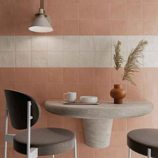 Restauracja ze ścianą wyłożoną pomarańczowymi płytkami bazowymi Stardust Cotto, z kinkietem, wiszącym stolikiem i dwoma krzesłami