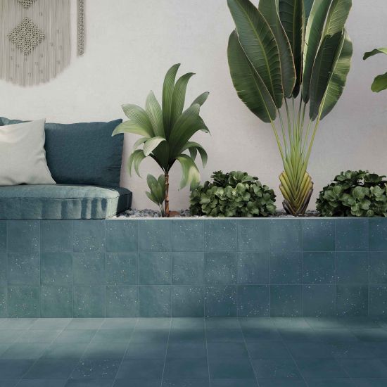 Taras wyłożony niebieskimi płytkami bazowymi Stardust Ocean, z poduszkami i roślinami