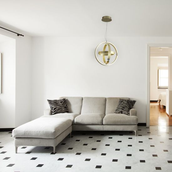 Salon z biało-czarną podłogą, szarą kanapą i złotą lampą wiszącą glamour Sirius