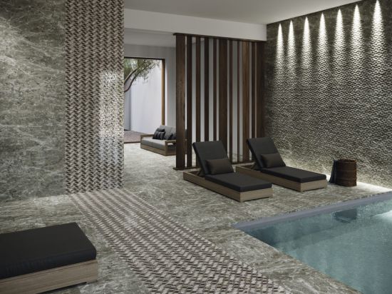 Luksusowe spa z basenem, ciemnymi leżakami, kanapą, drewnianym przepierzeniem i płytkami imitującymi kamień z kolekcji Sutton