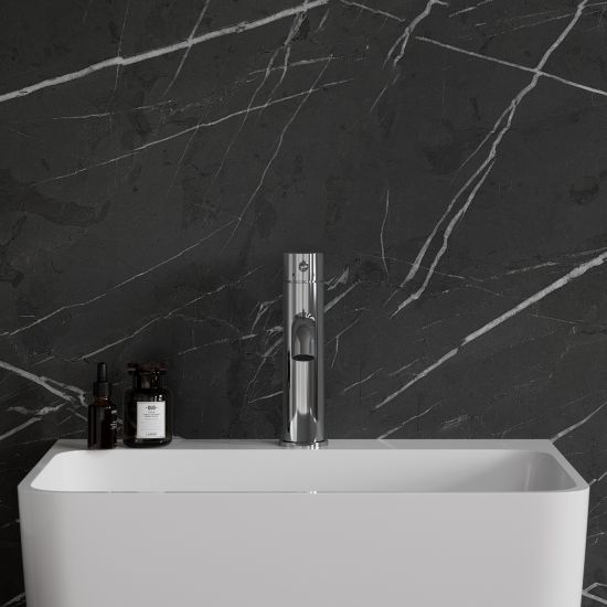 Widok od przodu na białą umywalkę z baterią stojącą w chromie Omnires Y na tle ciemnej ściany z białymi żyłami