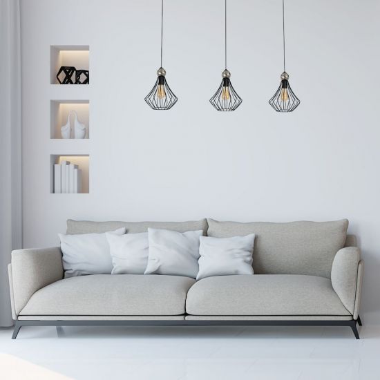 Jasny salon z jasną kanapą, czarną lampą wiszącą i trzema wnękami w ścianie na dekorację