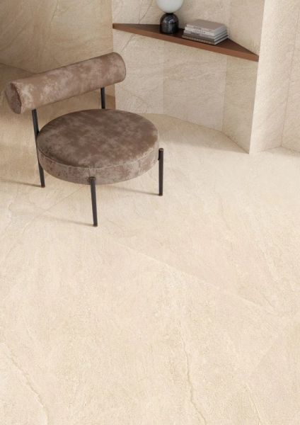 Nowoczesne płytki beżowe prostokątne na podłodze na tle małego fotelika brązowego