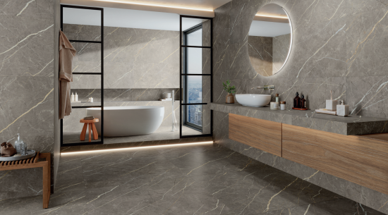 Duża łazienka wyłożona brązowymi płytkami imitującymi kamień Lab.Vein Taupe z wanną wolnostojącą i wiszącą szafką z blatem i umywalką nablatową oraz okrągłym lustrem